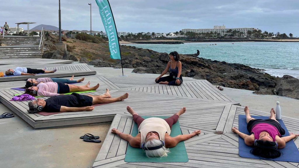 Yoga con cascos al aire libre en Lanzarote.